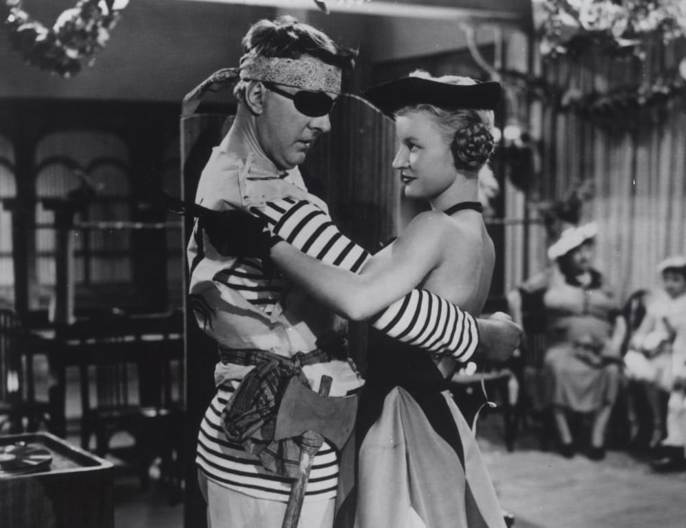 Two people dressed as pirates hold eachother in a dance ready position