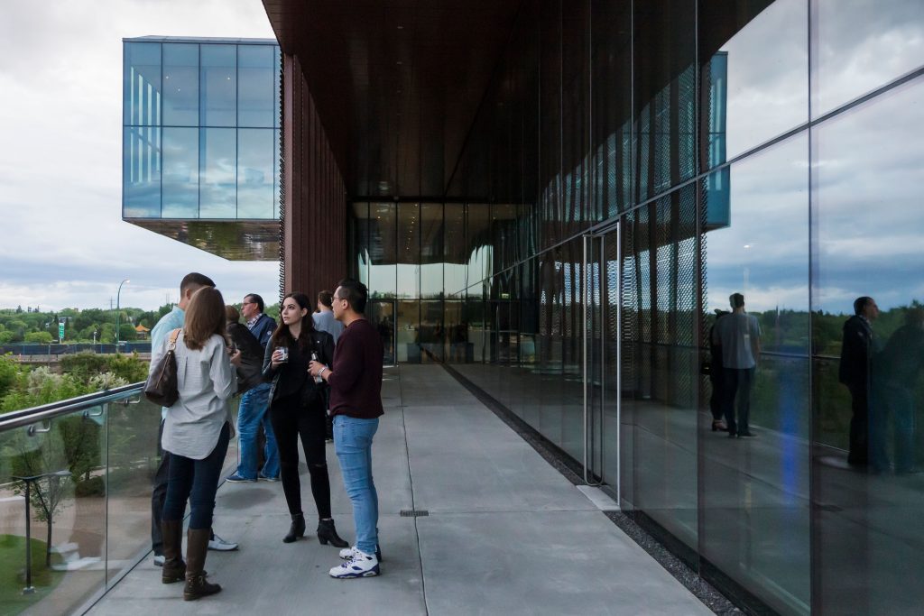 4 people standing around a table on the level 2 balcony