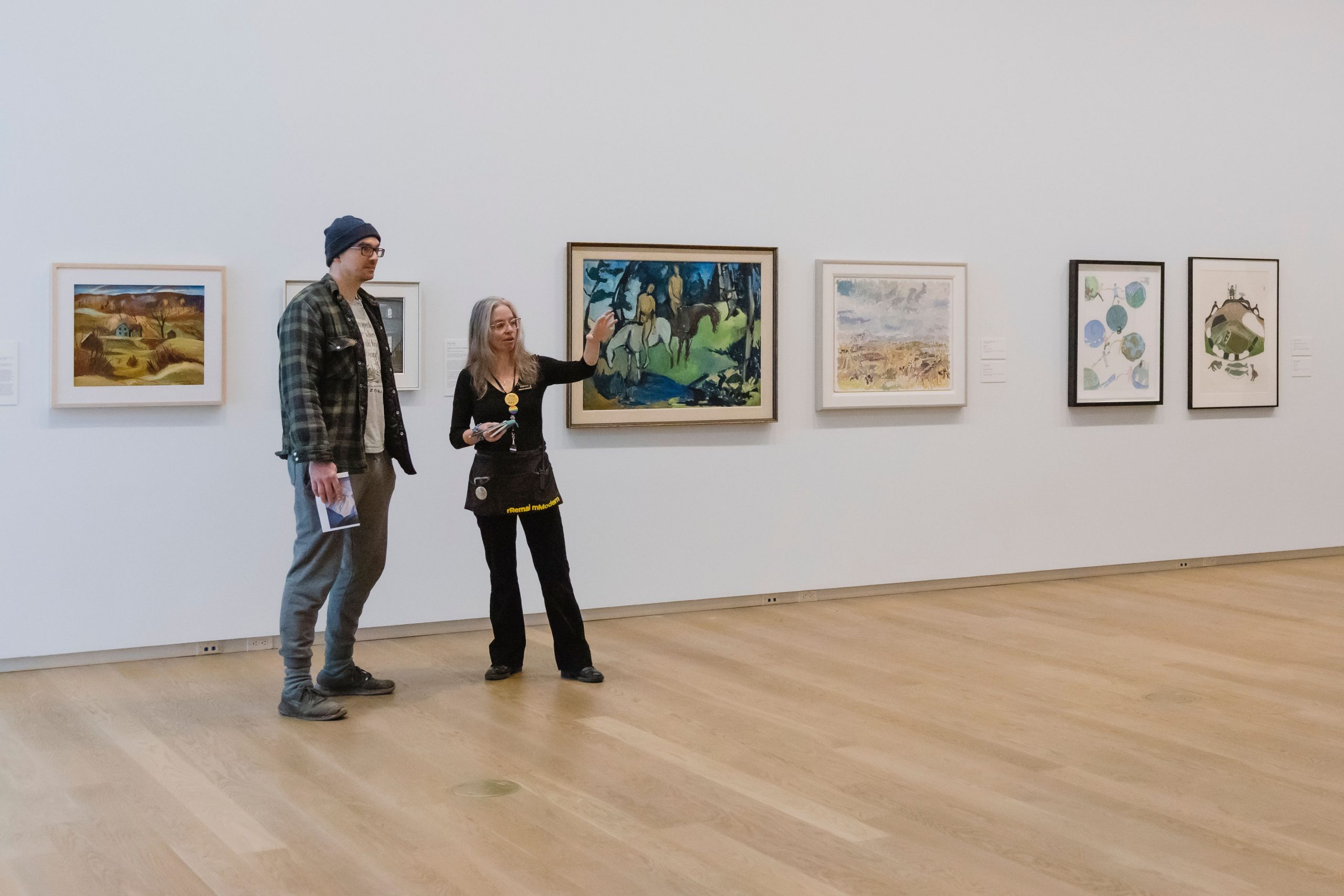 A Program Guide speaks with a visitor in the exhibition Views from the Blue House.